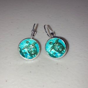 Z153- New- Costume jewelry- a pair of silver colored earrings with sea turtles.